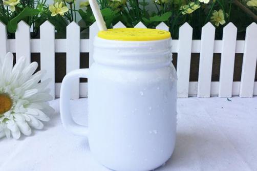 A glass with a lid and a straw